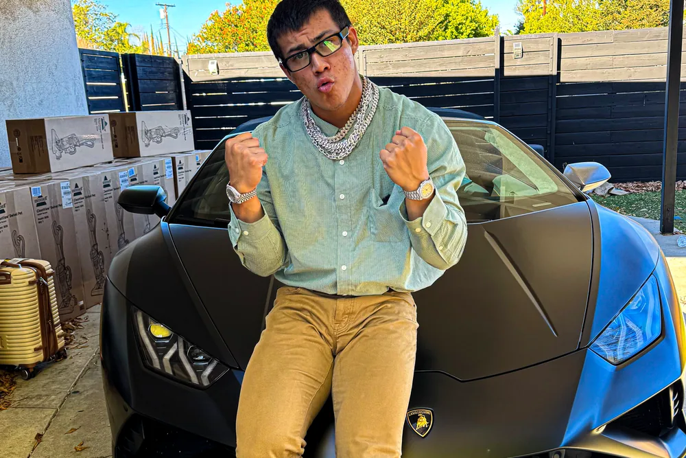 Togi sitting on the bonnet of a matte black Lamborghini